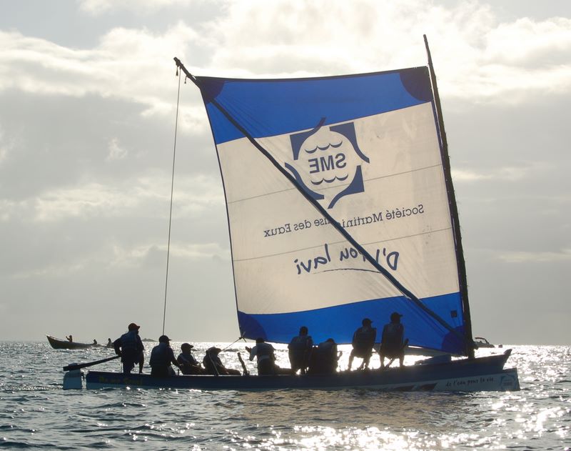 Crew of the Yole with blue sail